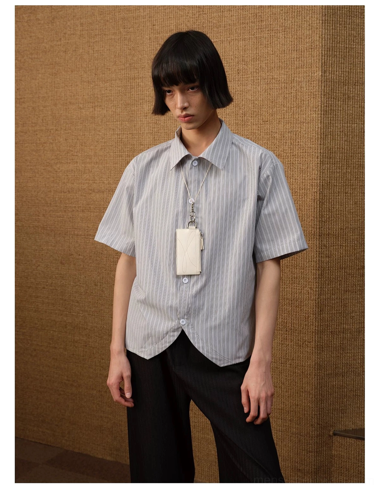 Front close-up showing the pointed collar, short sleeves, vertical pinstripes, and untucked curved hem