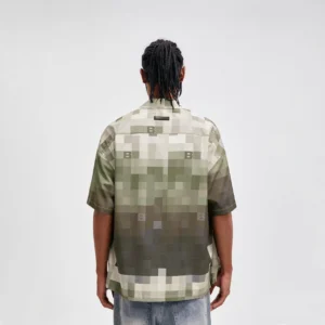 Back view of a relaxed pixel camo camp shirt showing the gradient camouflage print, drop shoulder silhouette, and clean streetwear hem