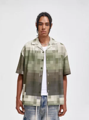 Front view of a pixel camouflage camp shirt with gradient green and brown print, relaxed Korean streetwear fit, short sleeves, and button front