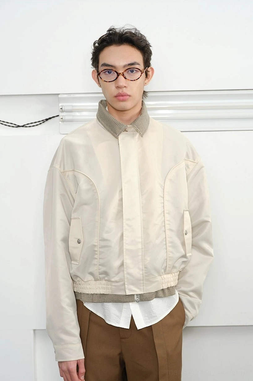 Plaid-lined cropped Harrington jacket close-up showing contrast check interior fabric and refined outer shell texture