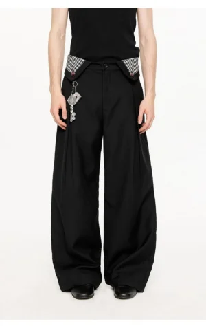 Black plaid waist detail wide-leg streetwear trousers shown in a full front model view with pleats, gingham waistband, and keychain charm