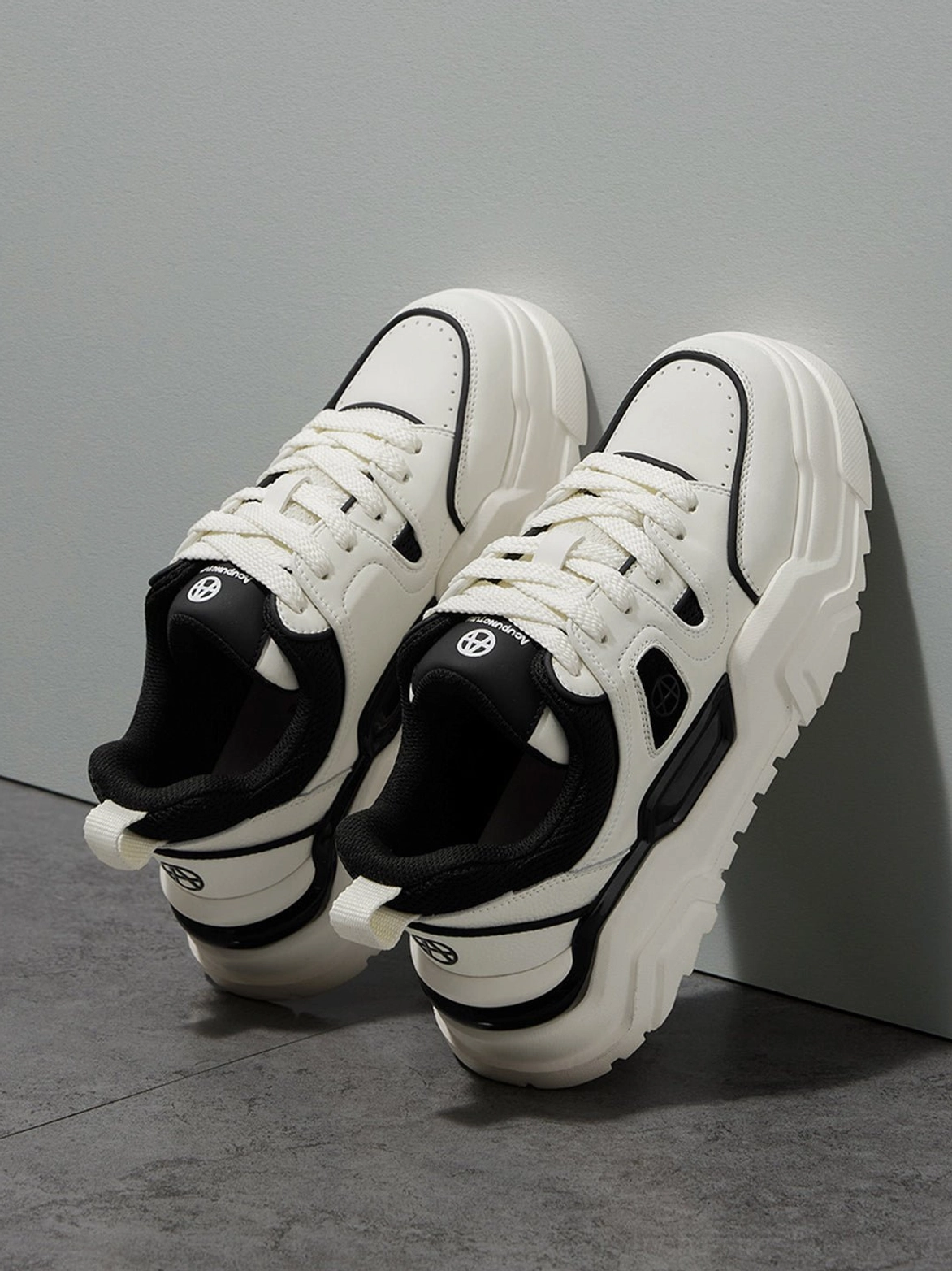 Side low-angle upward view of paired platform sneakers showing heel counter structure lace-up system and cushioned collar design details