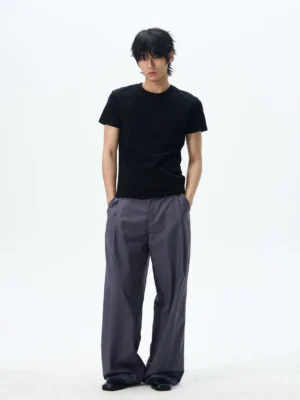 Male model wearing dark slate grey pleated wide leg dress pants with oversized relaxed Korean tailoring