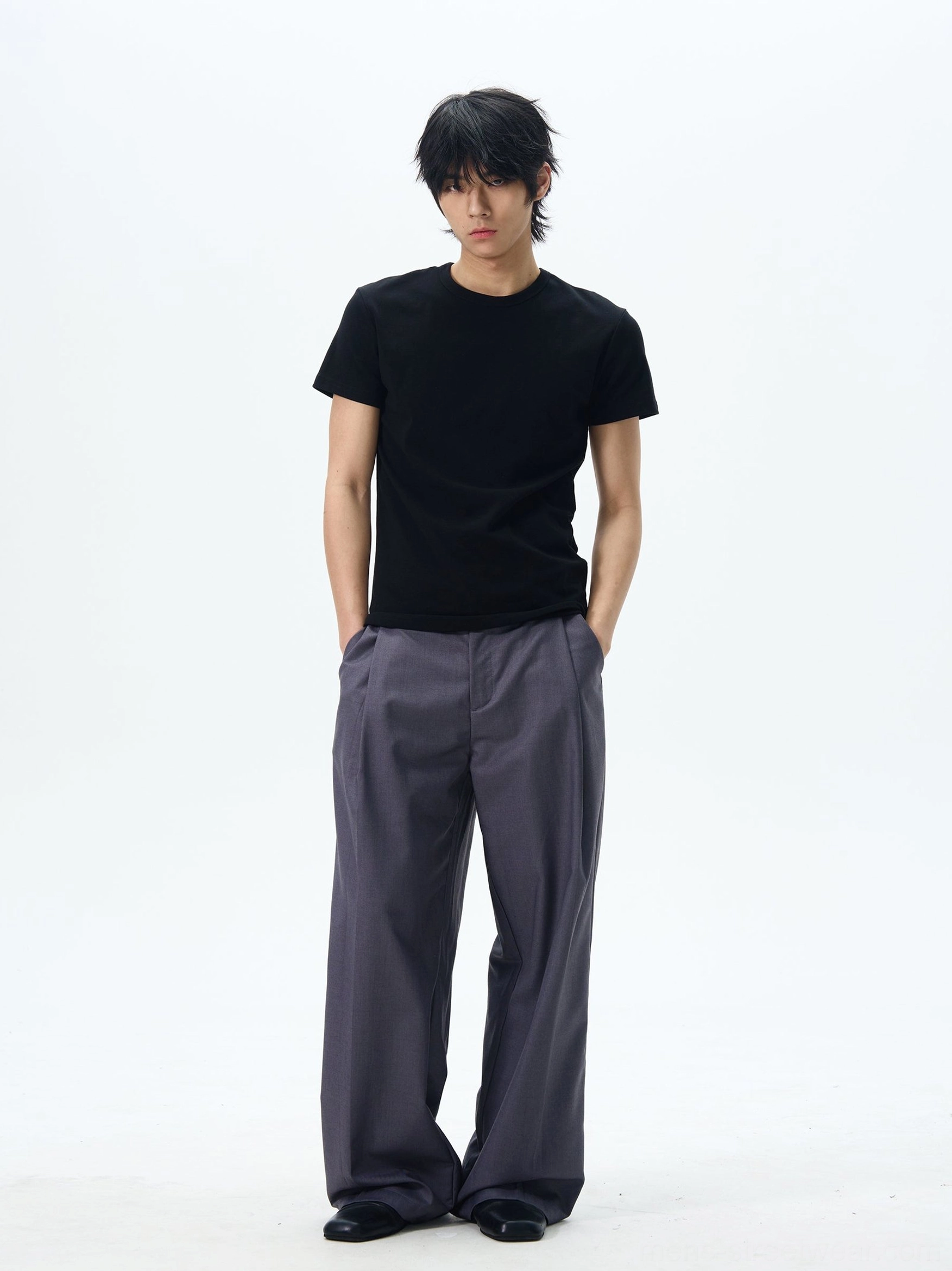 Male model wearing dark slate grey pleated wide leg dress pants with oversized relaxed Korean tailoring