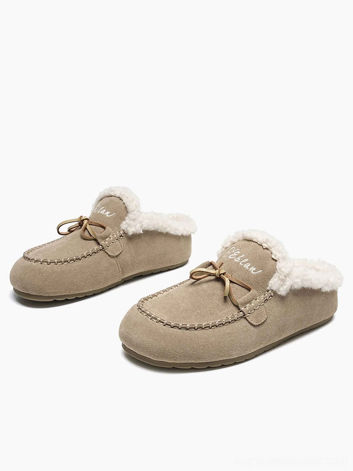 Pair of sand color suede-look moccasin slippers with soft plush collar and decorative bow lace on white background
