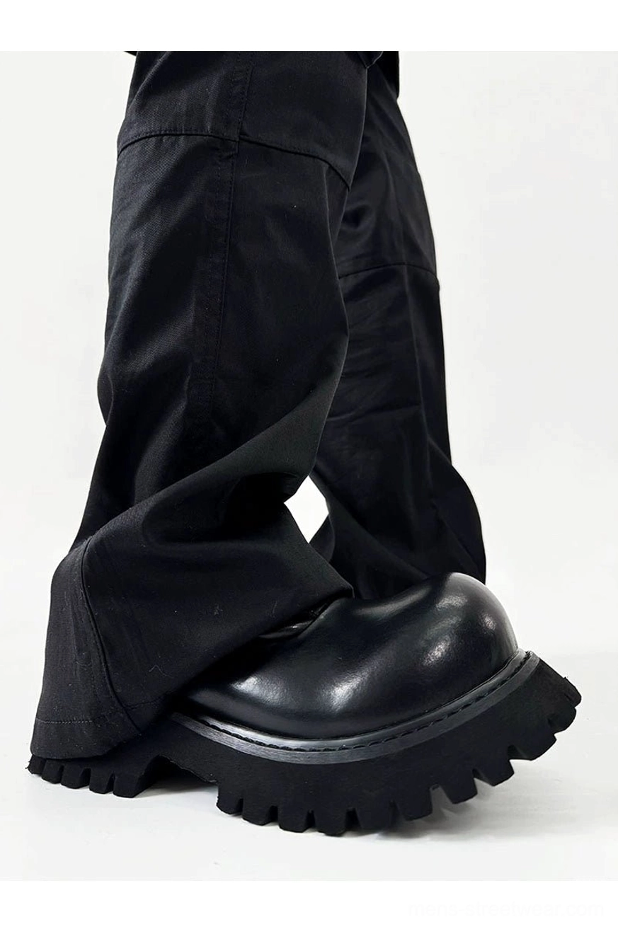 Side view of a polished black platform Derby shoe featuring a rounded toe and thick lug outsole