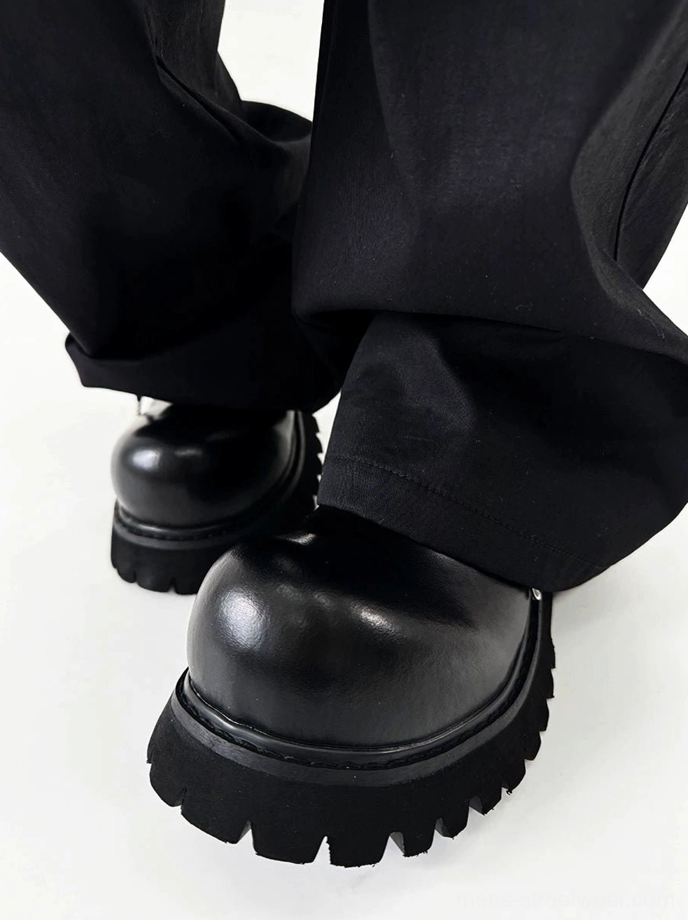Front low angle view of polished black platform Derby shoes with deep tread lug outsole