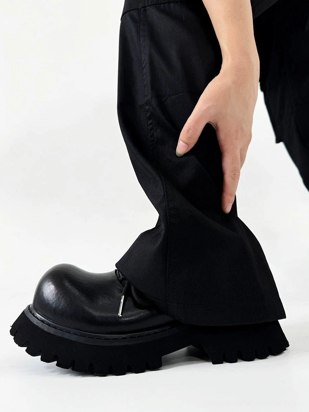 Polished black lug sole Derby shoe worn with black trousers showing round toe and welt stitching