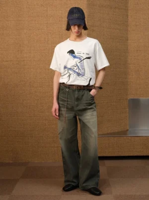 Full body view of white jazz sketch graphic T-shirt styled with navy cap, wide-leg jeans, leather belt and loafers