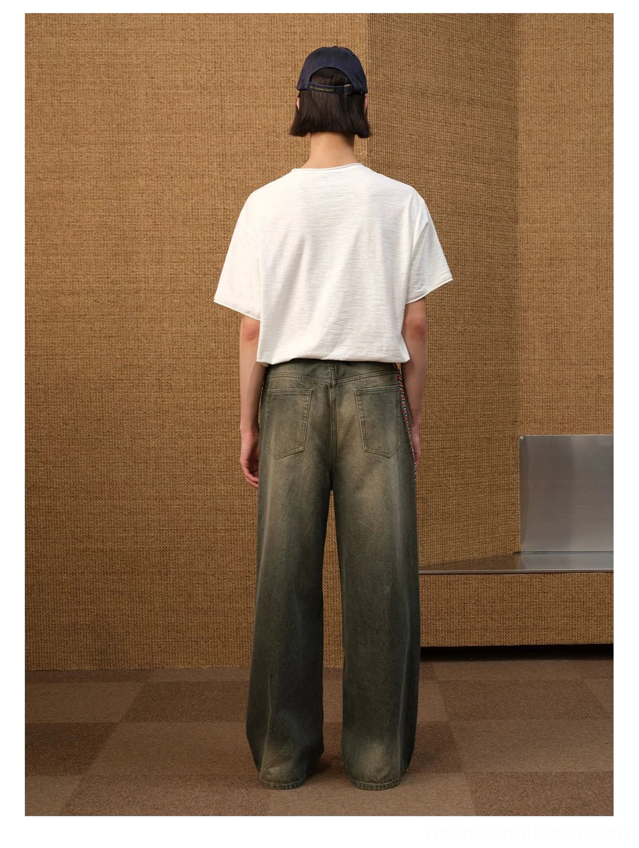 Back view of relaxed white cropped jazz sketch graphic T-shirt styled with navy cap and washed wide-leg denim
