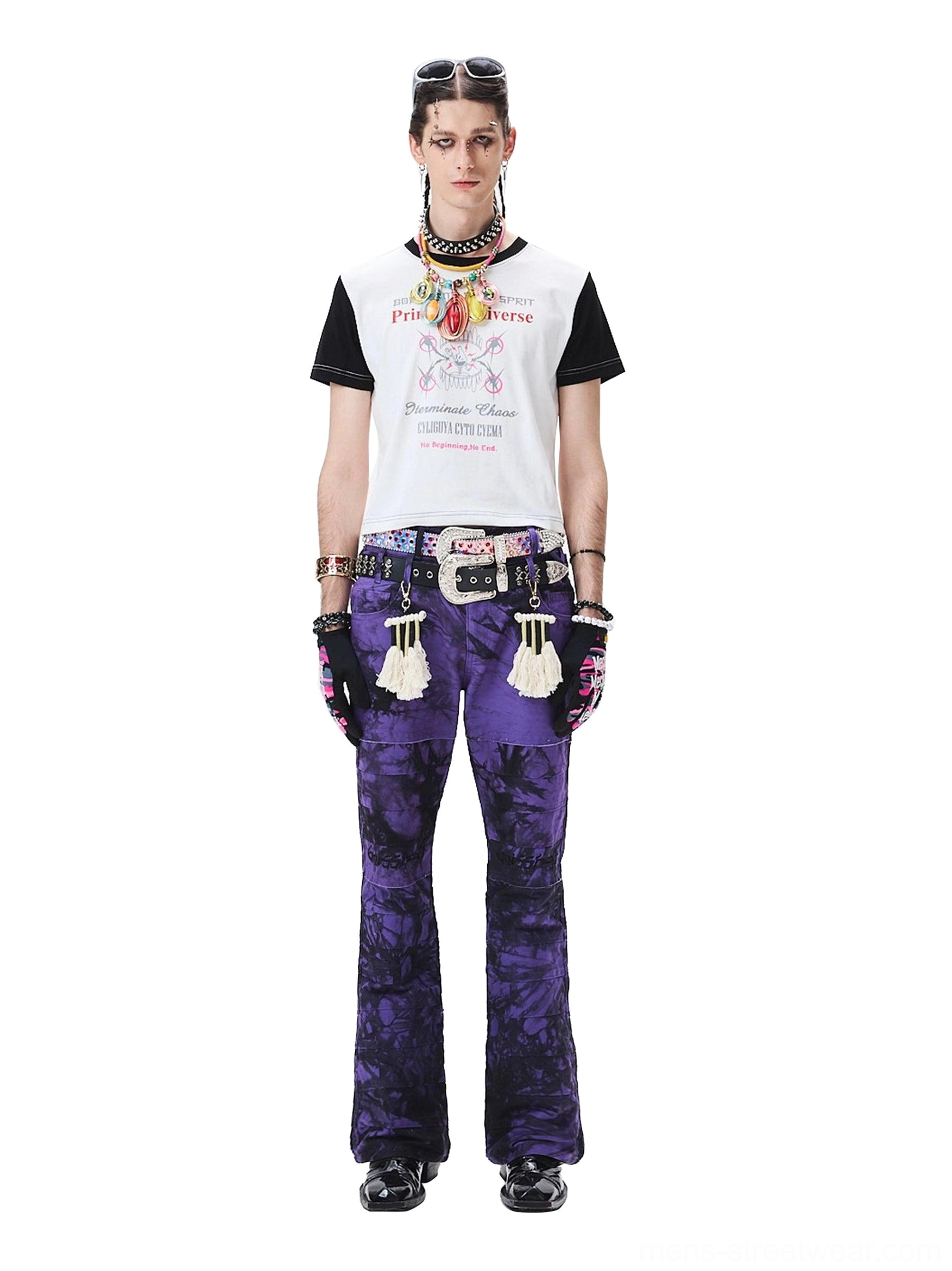 Androgynous model wearing purple tie-dye flared trousers with a cropped contrast sleeve top and statement streetwear jewelry