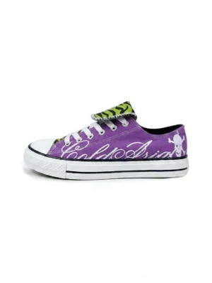 Purple low top canvas streetwear sneaker side profile with green zebra print tongue white cursive script skull heel graphic and white rubber sole