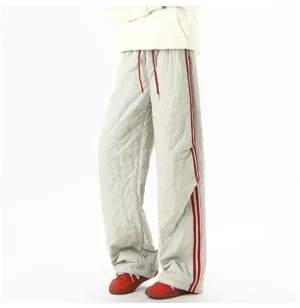 Gray quilted track pants with red side stripes shown in a low angle front view with drawstring waist and relaxed straight leg