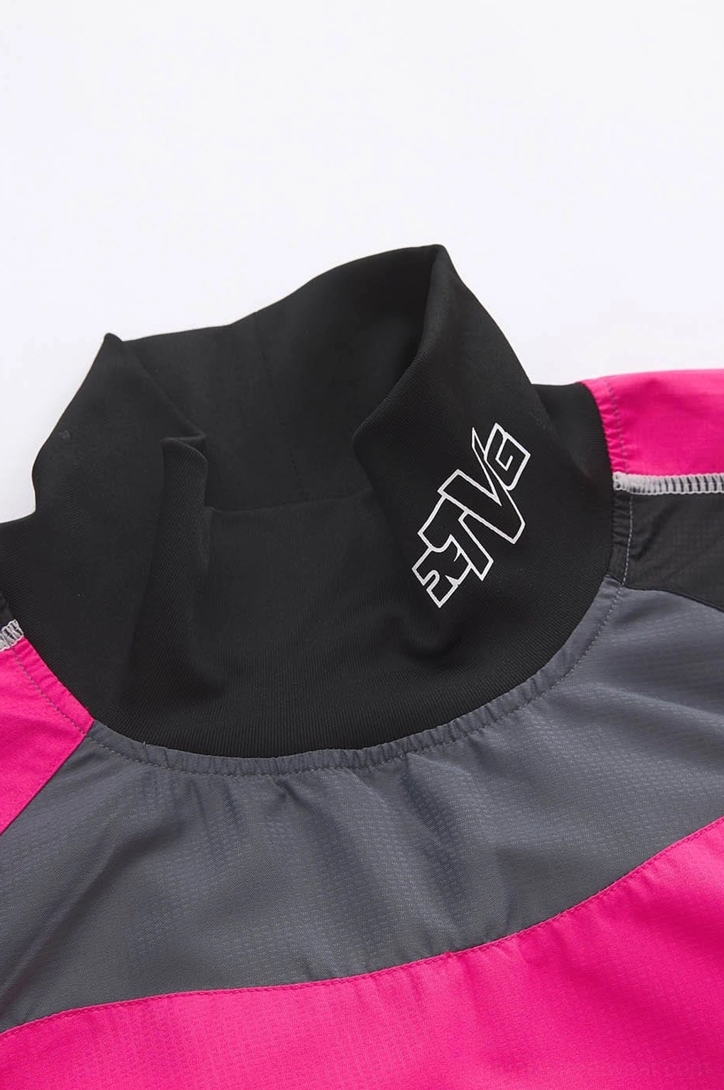 Close-up of black mock neck on color block racing raglan jersey with contrast pink grey and black panels