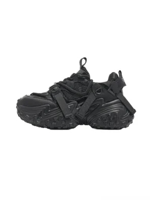 Black racing-tread chunky sport sneakers with technical mesh panels strap details and aggressive sculpted outsole on a white background
