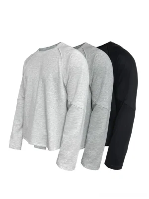 Front flat lay of raglan panelled crewneck sweatshirts in heather grey and black with ribbed collars and soft knit fabric