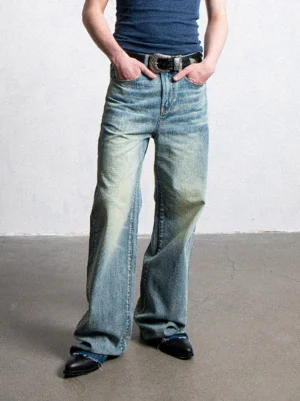 Front full-body view of raw-hem light-wash wide-leg jeans styled with a navy tank top and black leather shoes