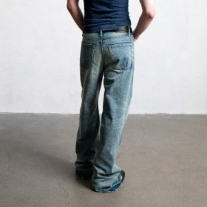 Rear view of light-wash wide-leg jeans showing back pockets, faded denim, and frayed raw hems