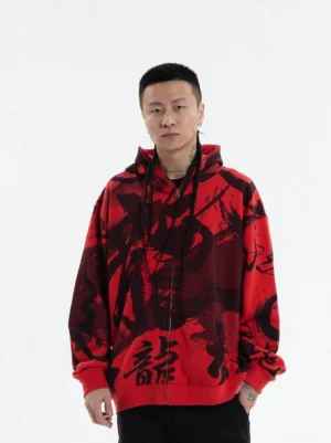 Front view of red black Chinese calligraphy graphic zip-up hoodie worn by male model on white studio background