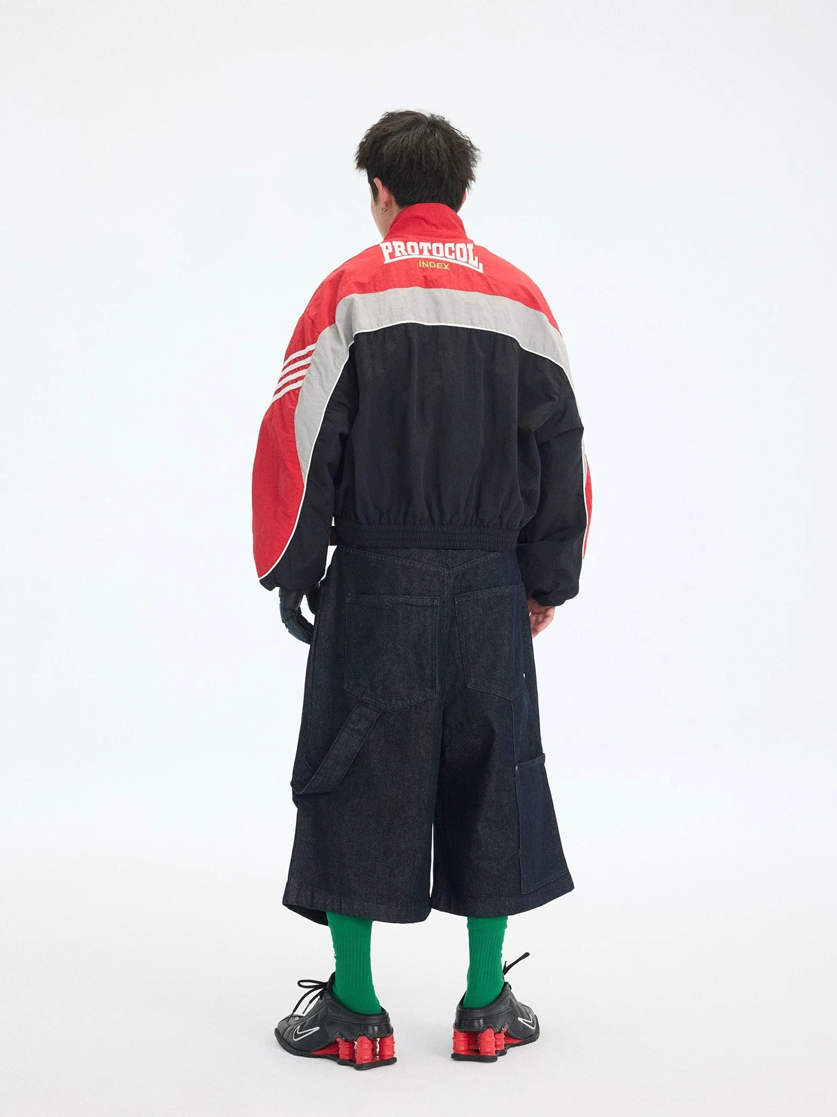 Back view of red and black cropped track jacket with silver grey accent panel and large rear graphic print