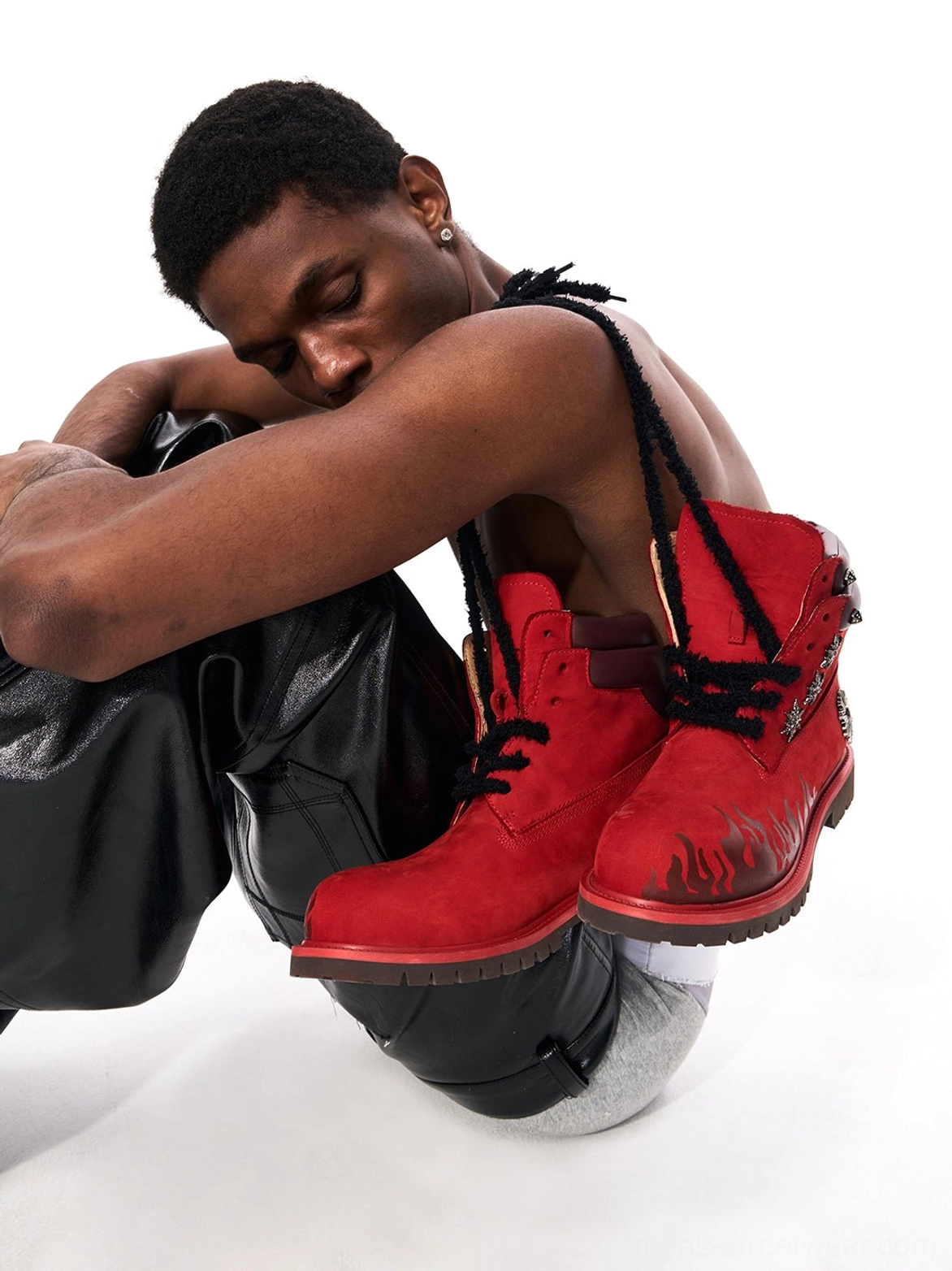 Red flame appliqué leather combat boots styled with black leather pants in an edgy streetwear look