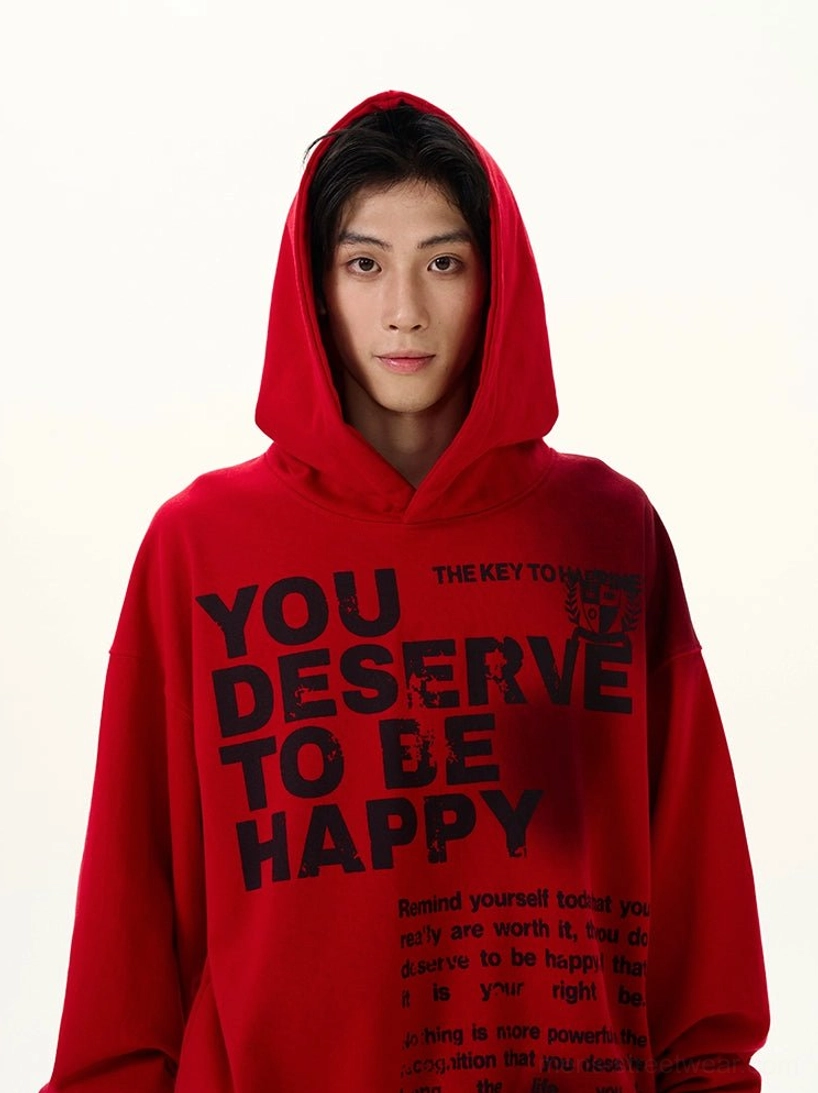 Close-up upper body view of red graphic hoodie with large motivational slogan print, full attached hood, drop shoulders, and loose oversized sleeves