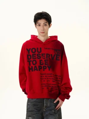 Front view of red oversized streetwear hoodie showing bold black graphic slogan print, relaxed silhouette, attached hood, ribbed trims, and casual Korean fashion styling