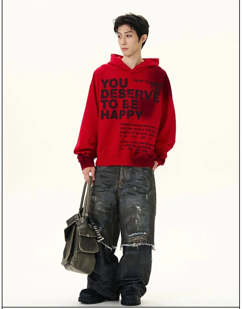 Left three-quarter view of red graphic oversized hoodie styled with distressed jeans and vintage leather tote bag in a contemporary urban streetwear outfit