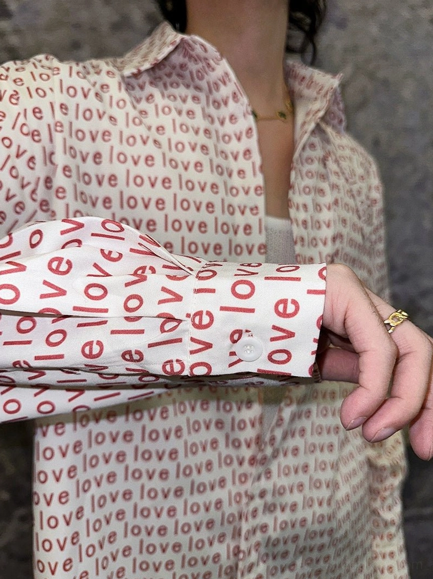 Close-up of classic collar and button cuff on red love print long-sleeve streetwear shirt