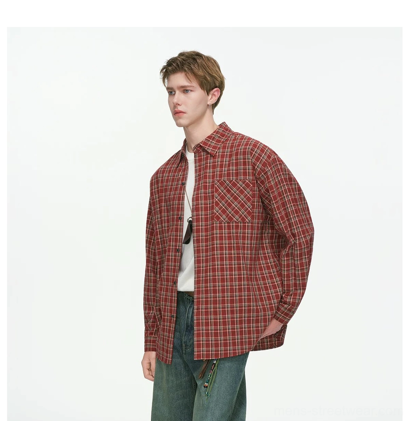 Red plaid oversized button-up shirt layered over a white undershirt with loose denim streetwear styling