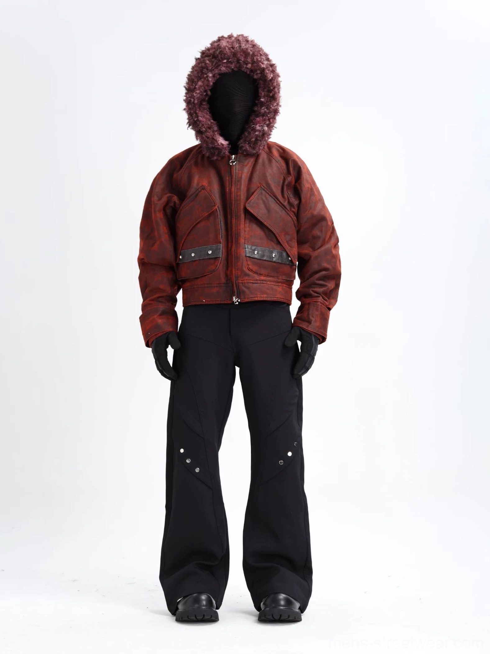 Full front view of a reddish brown distressed camo faux shearling hooded cropped bomber jacket styled with black flare pants, gloves, and dark leather shoes