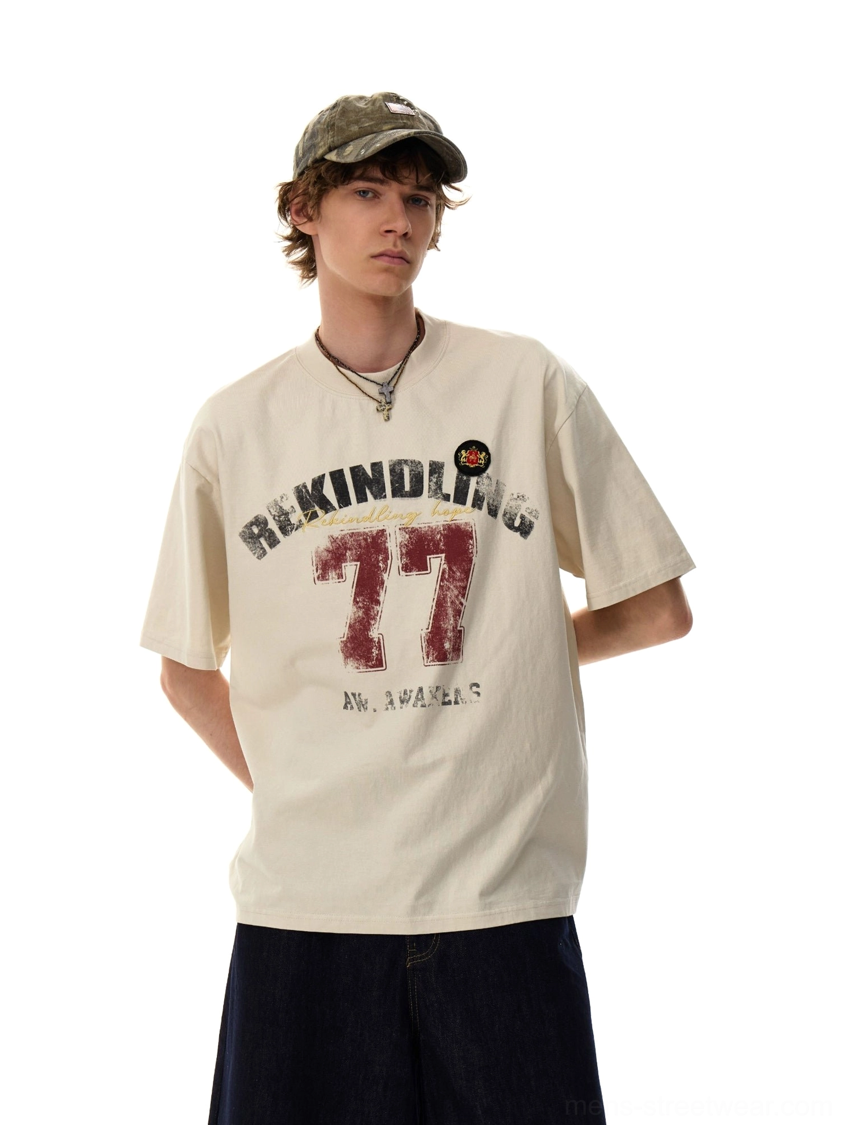 Model wearing the Apricot Rekindling 77 vintage graphic oversized T-shirt with wide-leg jeans and a camouflage baseball cap
