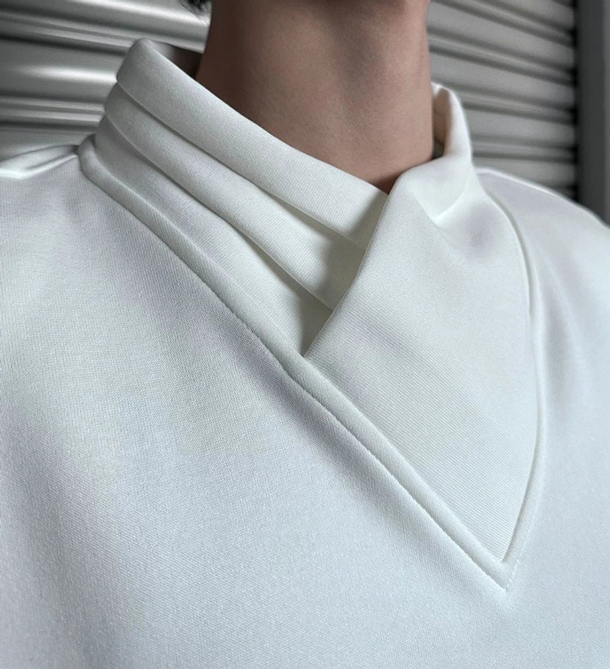 Relaxed asymmetric mock neck top with architectural neckline, solid color finish, and versatile East Asian citywear styling