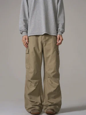 Front view of relaxed baggy wide-leg cargo pants with washed khaki cotton fabric, utility pockets, and natural streetwear creases