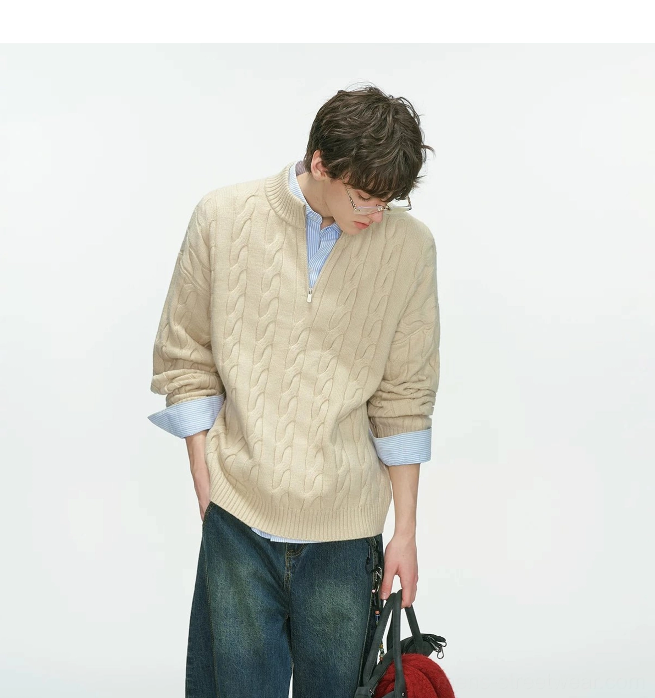 Downward front view of a relaxed beige cable knit half-zip sweater styled with a collared shirt and tote