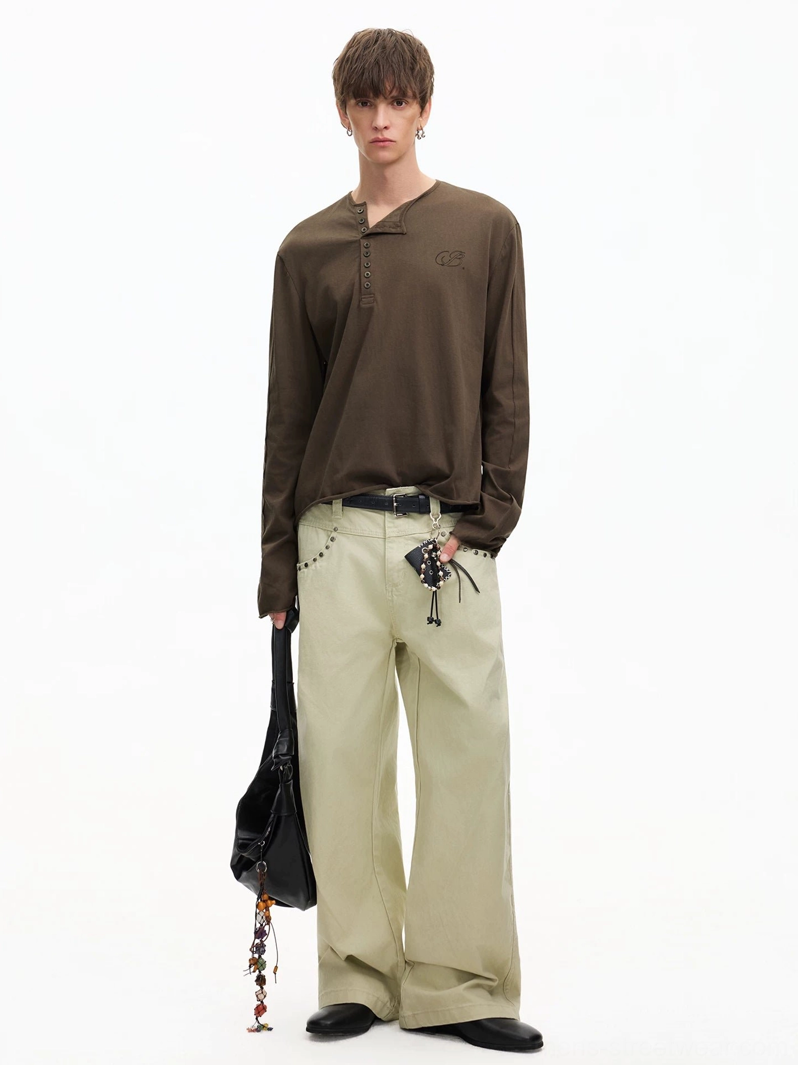 Side-front outfit view featuring a relaxed brown Henley tee with wide-leg khaki trousers and black tote bag