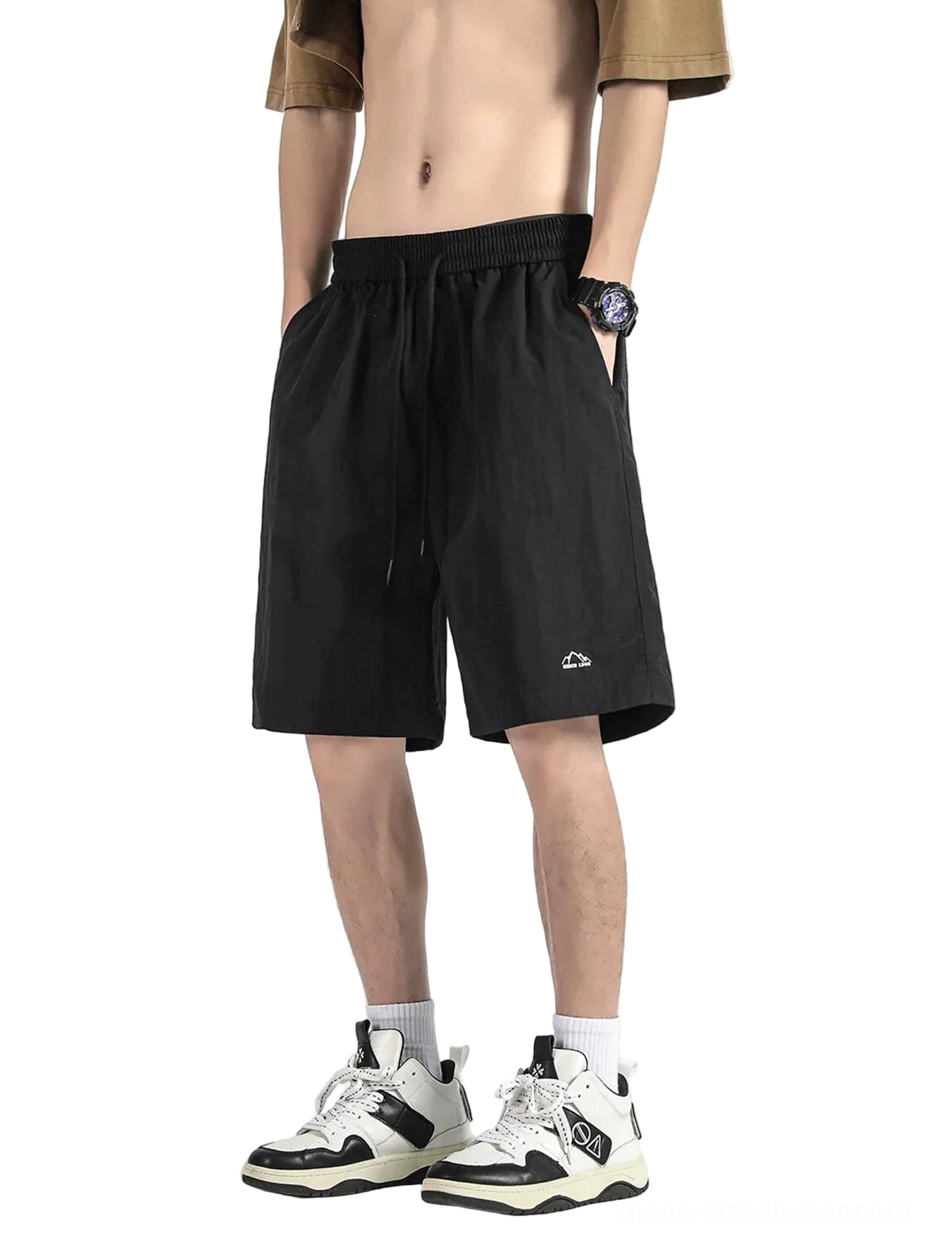 Black wide-leg knee-length streetwear shorts worn with a cropped top showing drawstring waistband and embroidered hem detail