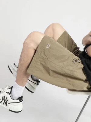Khaki relaxed polyester streetwear shorts with elastic drawstring waist and small embroidered mountain logo side view