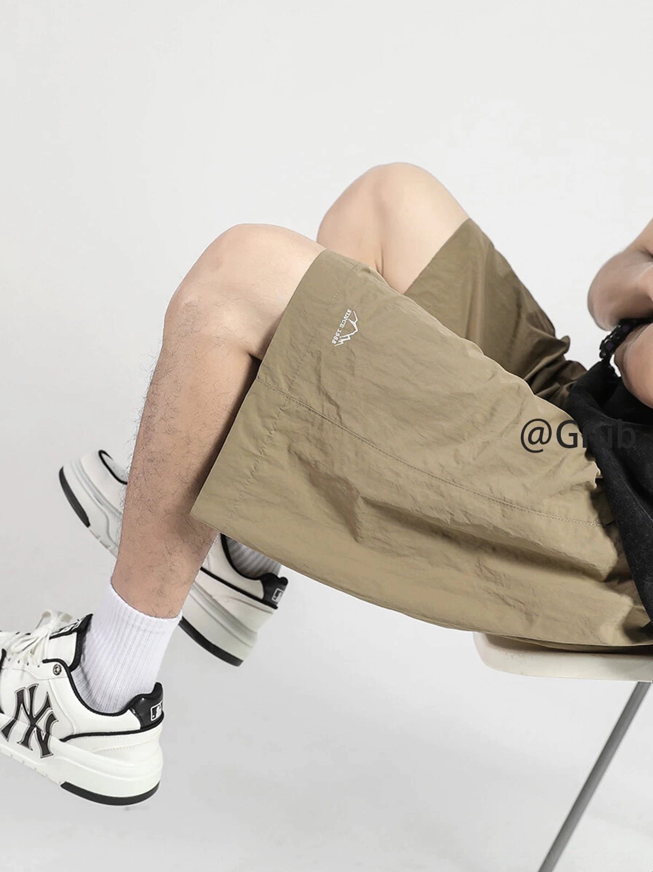 Khaki relaxed polyester streetwear shorts with elastic drawstring waist and small embroidered mountain logo side view