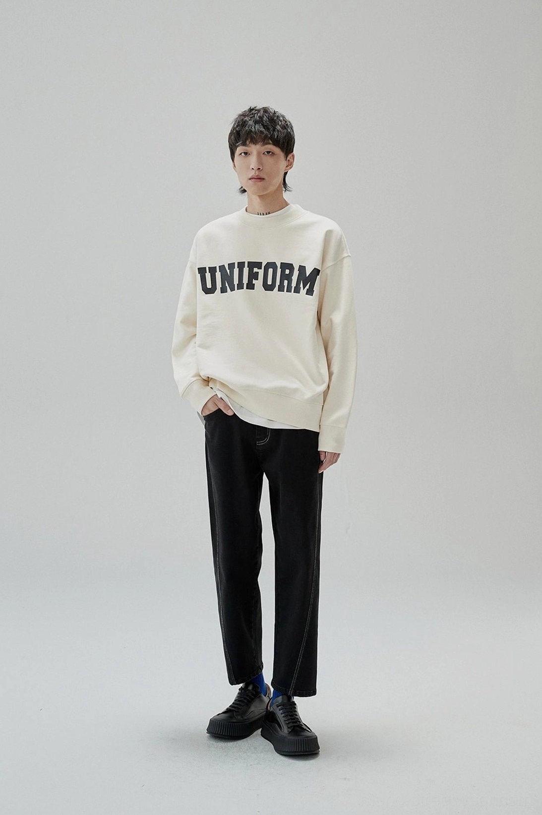 Relaxed graphic sweatshirt with collegiate typography and modern Korean fashion proportions