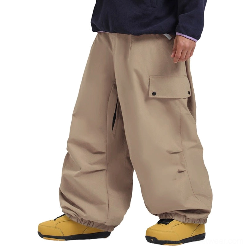 Relaxed oversized snowboard cargo pants featuring windproof polyester shell, wide-leg construction, secure cargo storage, elastic cuffs, and modern gorpcore styling