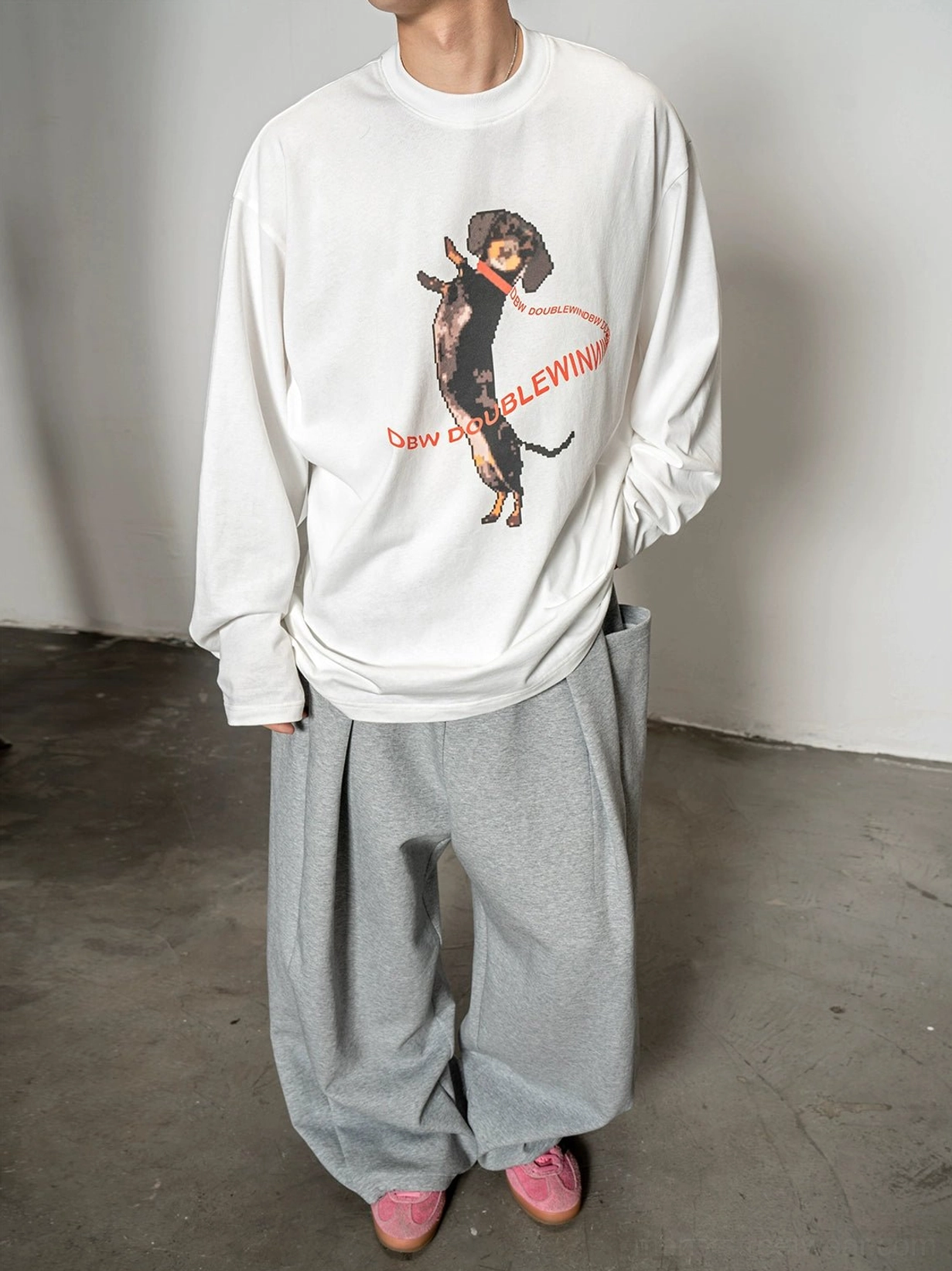 Side front view of a relaxed oversized white graphic long sleeve T-shirt with dachshund artwork and contrasting red lettering