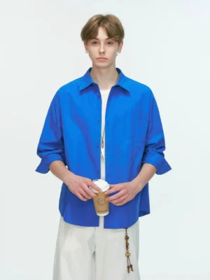 Blue relaxed poplin shirt with pointed collar and oversized long-sleeve Korean streetwear silhouette shown in a full-body studio view