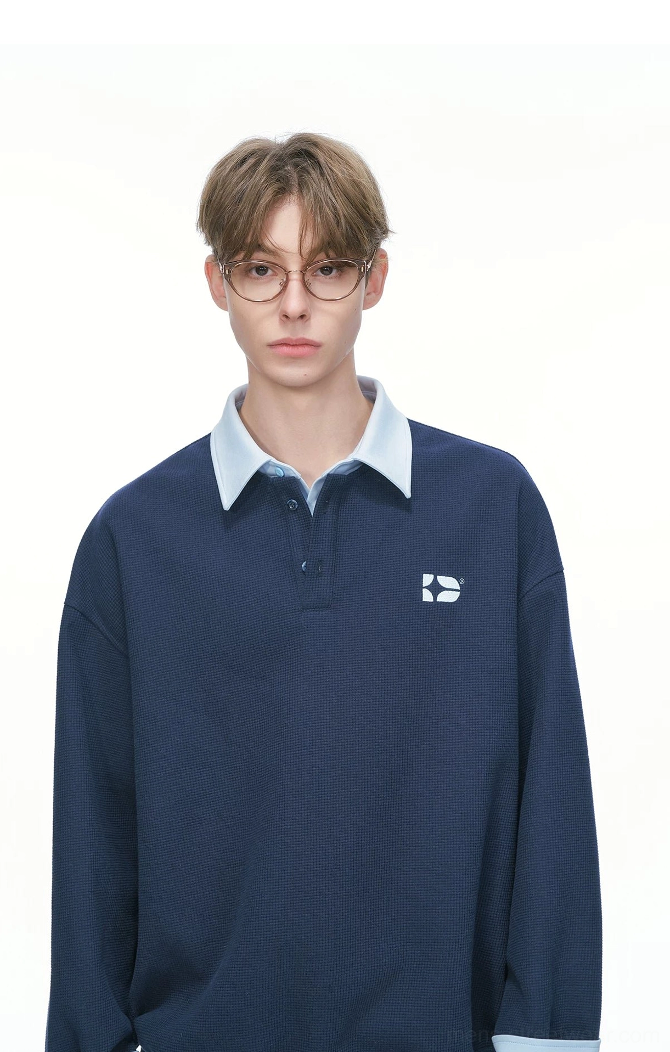 Relaxed rugby sweatshirt product detail with varsity collar dark contrast cuffs subtle texture and minimal embroidered chest logo