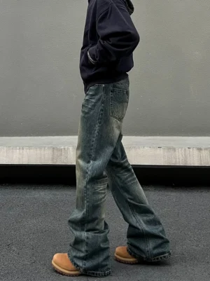 Side view of relaxed straight-leg vintage denim jeans styled with a navy hoodie and tan work boots for Korean streetwear