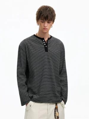 Black and white relaxed striped Henley long sleeve tee styled with off-white cargo pants in a studio front view