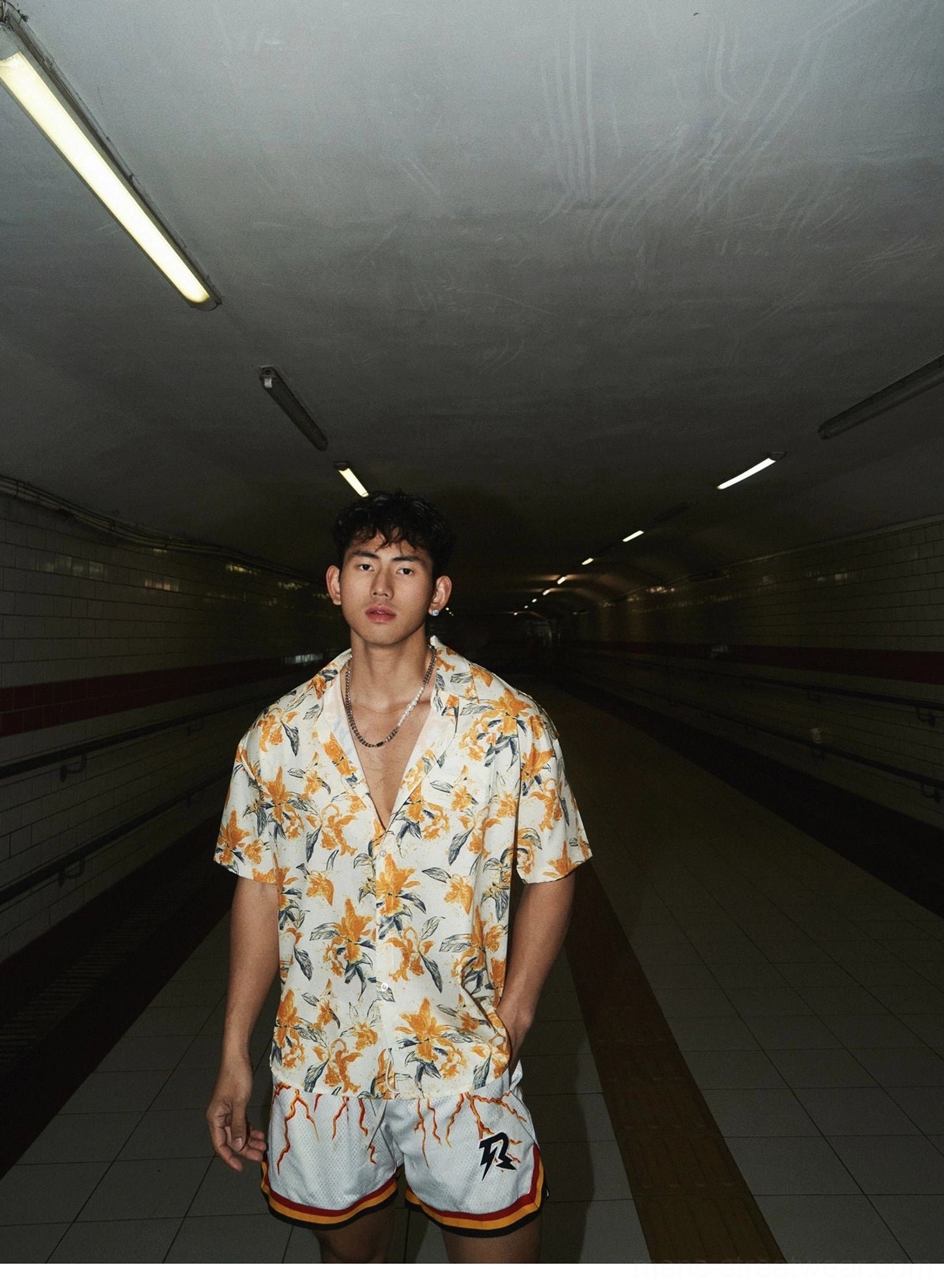 Front view of a relaxed tropical floral short sleeve shirt and white athletic shorts outfit in modern East Asian streetwear style