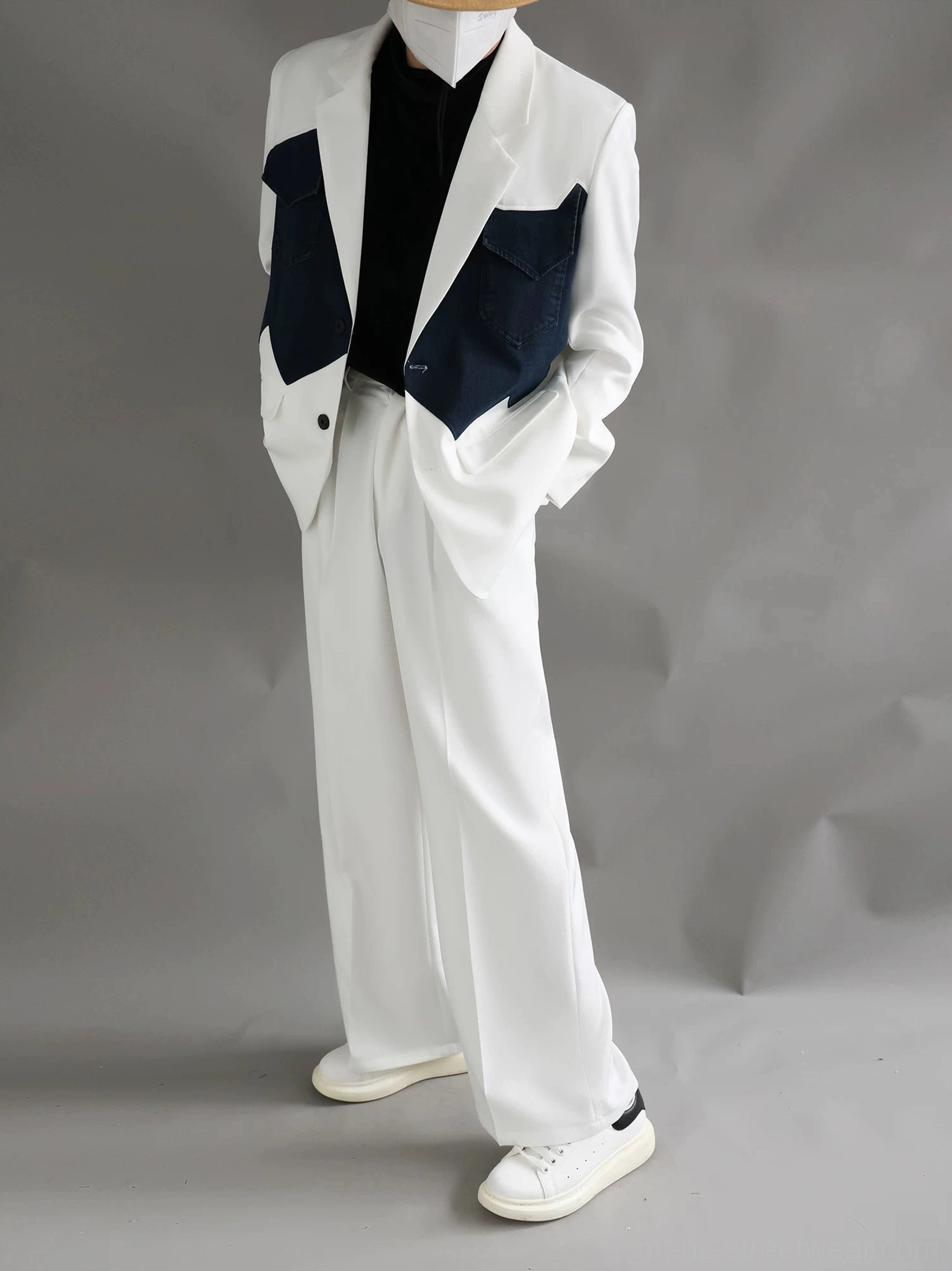 Three-quarter view of a relaxed two-piece Western color-block suit with ivory blazer, navy contrast panels, and wide-leg trousers
