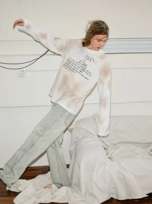 Side view of relaxed vintage straight-leg jeans styled with a tie-dye long-sleeve shirt for an effortless Seoul streetwear outfit