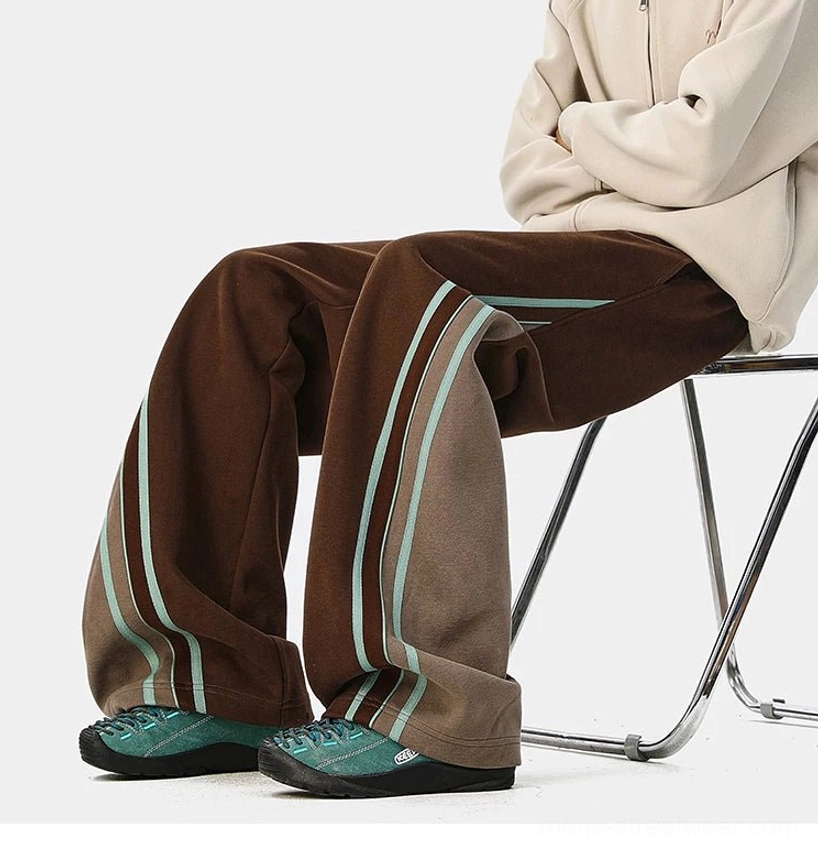 Relaxed wide-leg track pants with varsity-inspired side panels, adjustable drawstring waist, and oversized streetwear fit
